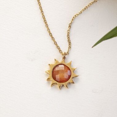 Sun necklace with orange stone, handmade brass pendant plated in 24k gold on a stainless steel chain. Vibrant celestial-inspired artisan jewelry, elegant handmade accessory, affordable wearable art by Sunny Designs small business. Κολιέ Sun με πορτοκαλί πέτρα, χειροποίητο μενταγιόν από ορείχαλκο επιχρυσωμένο 24 καράτια σε ατσάλινη αλυσίδα. Ζωντανό κόσμημα εμπνευσμένο από τα ουράνια σύμβολα, κομψό χειροποίητο αξεσουάρ, προσιτή φορετή τέχνη από τη μικρή επιχείρηση Sunny Designs.