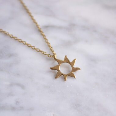 Sunny necklace with stainless steel chain and 24k gold plated brass sun pendant. Handmade artisan jewelry inspired by celestial symbols, elegant statement accessory, affordable wearable art by Sunny Designs small business.Κολιέ Sunny με ατσάλινη αλυσίδα και μενταγιόν ήλιου από ορείχαλκο επιχρυσωμένο με 24 καράτια. Χειροποίητο κόσμημα εμπνευσμένο από τα ουράνια σύμβολα, κομψό statement αξεσουάρ, προσιτή τέχνη φορετή από τη μικρή επιχείρηση Sunny Designs.