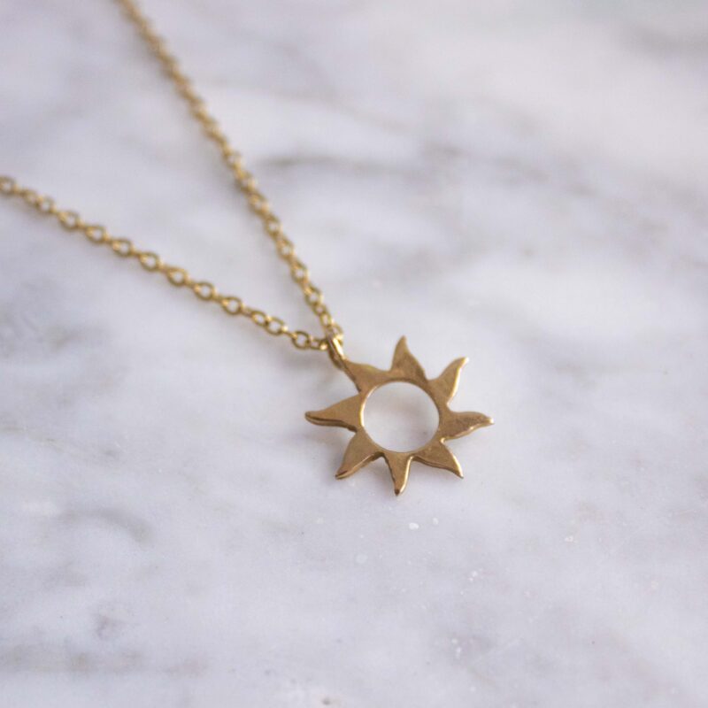 Sunny necklace with stainless steel chain and 24k gold plated brass sun pendant. Handmade artisan jewelry inspired by celestial symbols, elegant statement accessory, affordable wearable art by Sunny Designs small business.Κολιέ Sunny με ατσάλινη αλυσίδα και μενταγιόν ήλιου από ορείχαλκο επιχρυσωμένο με 24 καράτια. Χειροποίητο κόσμημα εμπνευσμένο από τα ουράνια σύμβολα, κομψό statement αξεσουάρ, προσιτή τέχνη φορετή από τη μικρή επιχείρηση Sunny Designs.