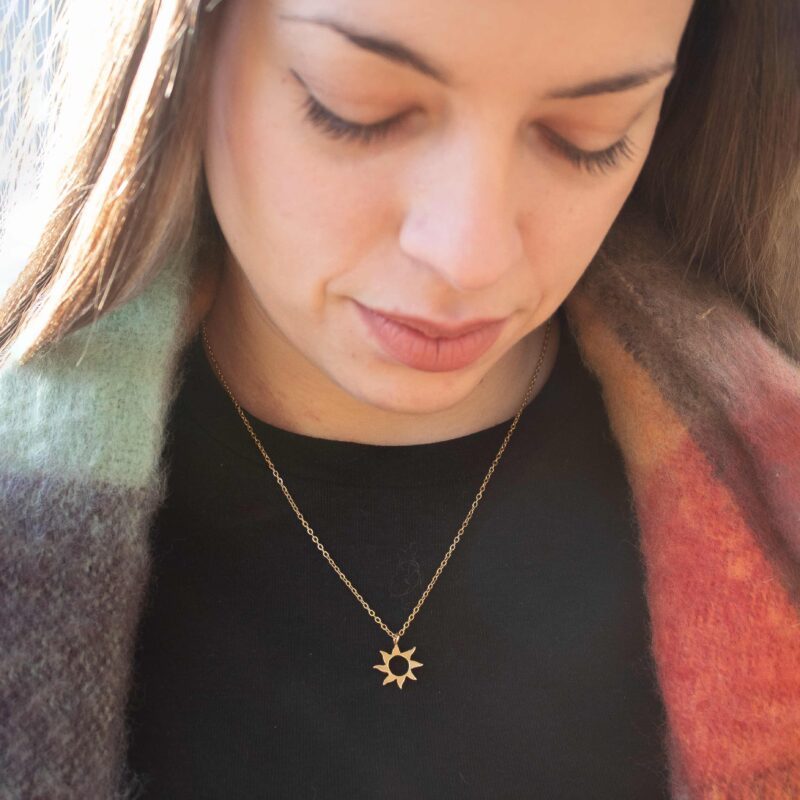 Sunny necklace with stainless steel chain and 24k gold plated brass sun pendant. Handmade artisan jewelry inspired by celestial symbols, elegant statement accessory, affordable wearable art by Sunny Designs small business.Κολιέ Sunny με ατσάλινη αλυσίδα και μενταγιόν ήλιου από ορείχαλκο επιχρυσωμένο με 24 καράτια. Χειροποίητο κόσμημα εμπνευσμένο από τα ουράνια σύμβολα, κομψό statement αξεσουάρ, προσιτή τέχνη φορετή από τη μικρή επιχείρηση Sunny Designs.