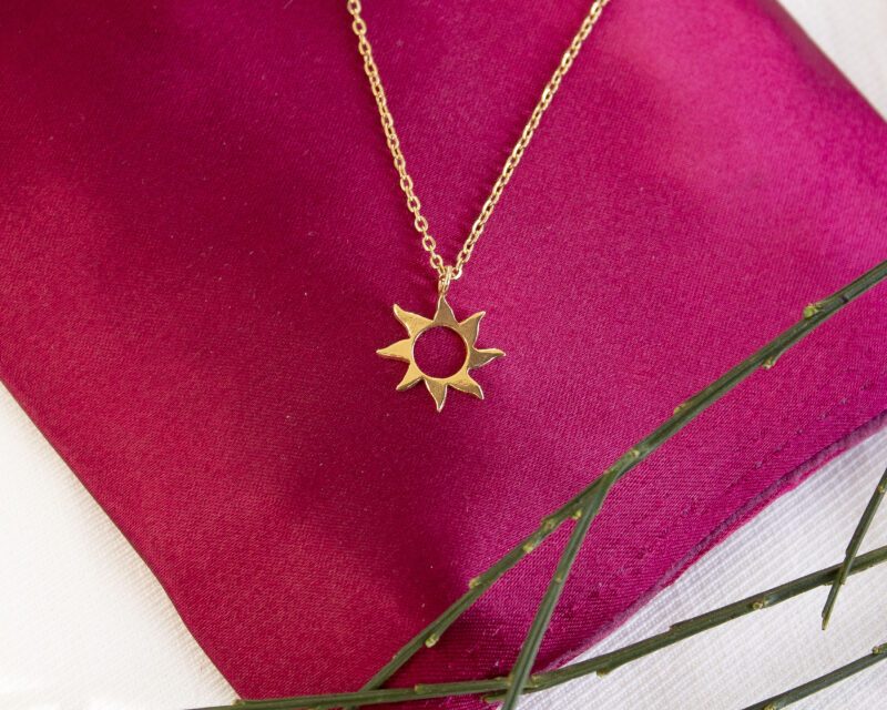 Sunny necklace with stainless steel chain and 24k gold plated brass sun pendant. Handmade artisan jewelry inspired by celestial symbols, elegant statement accessory, affordable wearable art by Sunny Designs small business.Κολιέ Sunny με ατσάλινη αλυσίδα και μενταγιόν ήλιου από ορείχαλκο επιχρυσωμένο με 24 καράτια. Χειροποίητο κόσμημα εμπνευσμένο από τα ουράνια σύμβολα, κομψό statement αξεσουάρ, προσιτή τέχνη φορετή από τη μικρή επιχείρηση Sunny Designs.