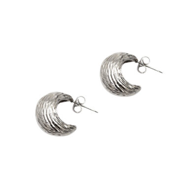 Close-up image of silver hoop earrings, showcasing their sleek and classic design. Κοντινή εικόνα ασημένιων σκουλαρικιών σε σχήμα κύκλου, επιδεικνύοντας το λείο και κλασικό σχέδιό τους.