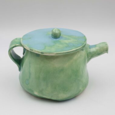 An artisan-crafted ceramic teapot, skillfully formed and glazed by hand. Its smooth surface showcases intricate textures and delicate patterns, reflecting the artisan's meticulous craftsmanship. The teapot's graceful curves and elegant spout evoke a sense of timeless beauty and functionality, inviting contemplation and appreciation of its artisanal quality.