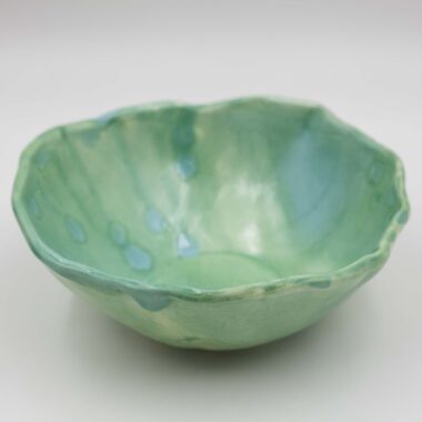 A close-up image of a green ceramic glazed handmade bowl . The bowl exhibits a smooth texture with intricate details, showcasing its artisanal craftsmanship and glossy finish." Κοντινή εικόνα ενός πράσινου κεραμικού γυαλισμένου χειροποίητου μπολ. Το μπολ εμφανίζει μια ομαλή υφή με λεπτομερείς λεπτομέρειες, επιδεικνύοντας τη χειροτεχνία του τεχνίτη και το γυαλιστερό τελείωμά του.
