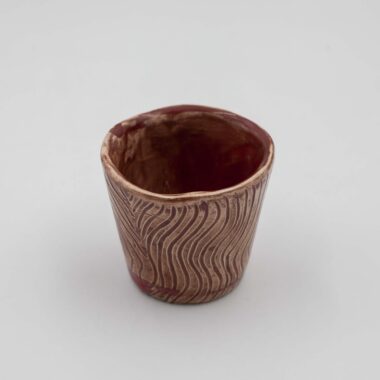 handmade ceramic mugs with a unique glazing technique. The mugs feature a rich, deep red color with subtle variations and textures, creating a visually captivating effect. The special glazing adds depth and dimension to the mugs' surface, making them both functional and aesthetically pleasing.