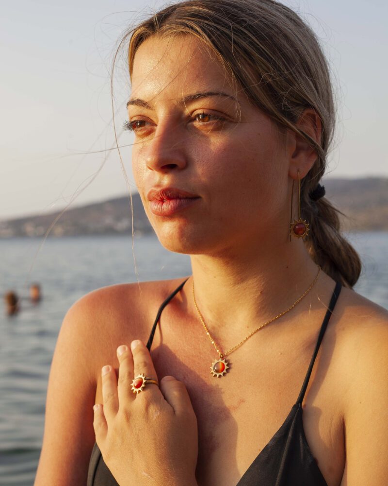 Sun necklace with brown cat’s eye stone, handmade brass pendant plated in 24k gold on a stainless steel chain. Unique celestial-inspired artisan jewelry with shimmering cat’s eye detail, affordable handmade accessory by Sunny Designs small business.Κολιέ Sun με καφέ πέτρα cat’s eye, χειροποίητο μενταγιόν από ορείχαλκο επιχρυσωμένο 24 καράτια σε ατσάλινη αλυσίδα. Μοναδικό κόσμημα εμπνευσμένο από τα ουράνια σύμβολα με λαμπερή λεπτομέρεια cat’s eye, προσιτό χειροποίητο αξεσουάρ από τη μικρή επιχείρηση Sunny Designs.