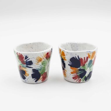 Handmade ceramic cups featuring delicate floral designs, showcasing intricate craftsmanship and artistic detail. Χειροποίητα κεραμικά φλιτζάνια με λουλούδια, παρουσιάζοντας λεπτομερή τεχνική και καλλιτεχνική λεπτομέρεια.
