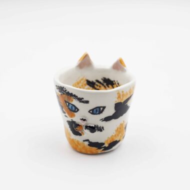 Handmade ceramic cup shaped like a playful cat, showcasing exquisite craftsmanship and artistic flair. Χειροποίητο κεραμικό φλιτζάνι σε σχήμα γάτας, δείχνοντας υπέροχη τεχνοτροπία και καλλιτεχνική αίσθηση.