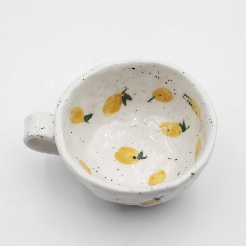 Hand-drawn handmade mug featuring vibrant lemons, adding a pop of citrusy charm to your morning routine. Χειροποίητο κύπελλο με ζωγραφισμένα λεμόνια, προσθέτοντας μια νότα κίτρινης γοητείας στην καθημερινή σας ρουτίνα.