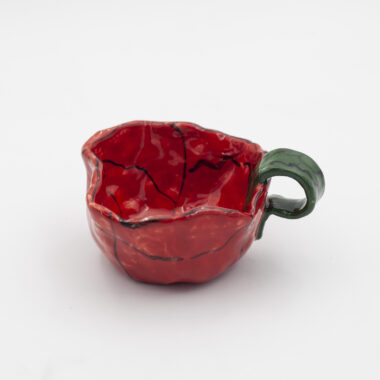 Μια χειροποίητη κούπα παπαρούνα. A handmade mug adorned with poppy flowers.