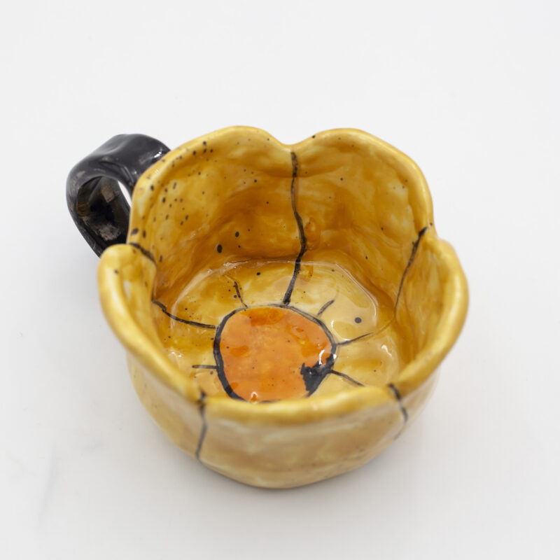 Μια χειροποίητη κούπα μαργαρίτα. A handmade mug adorned with daisy flowers.