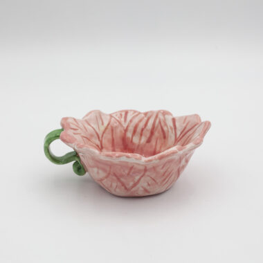 Μια χειροποίητη κεραμική κούπα με σχήμα λουλουδιού. A handmade ceramic mug shaped like a flower.