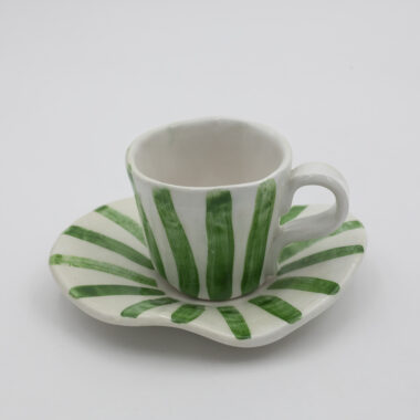 Ένα χειροποίητο κεραμικό φλιτζάνι με πιατάκι και πράσινες μινιμαλιστικές γραμμές. A handmade ceramic cup with saucer adorned with green minimalistic lines.