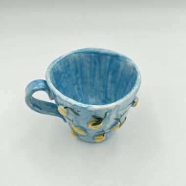 Handmade ceramic mug featuring 3D lemons, perfect for enjoying your favorite beverage. This unique mug combines artisanal craftsmanship with a vibrant, fruity design, making it an ideal gift for lemon lovers and collectors. Χειροποίητη κεραμική κούπα με 3D λεμόνια, ιδανική για να απολαμβάνετε το αγαπημένο σας ρόφημα. Αυτή η μοναδική κούπα συνδυάζει την τεχνογνωσία της χειροποίητης τέχνης με ένα ζωντανό, φρουτώδες σχέδιο, κάνοντάς την ιδανικό δώρο για τους λάτρεις των λεμονιών και συλλέκτες.