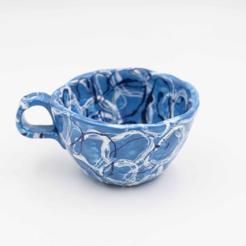 Handmade ceramic mug featuring a painted water design, perfect for nature lovers and art enthusiasts. This unique, artisanal mug showcases the fluid beauty of water with intricate details and calming colors. Ideal for enjoying your favorite beverage, it adds a touch of artistic elegance to your home or office. Χειροποίητη κεραμική κούπα με ζωγραφισμένο σχέδιο νερού, ιδανική για τους λάτρεις της φύσης και της τέχνης. Αυτή η μοναδική, καλλιτεχνική κούπα αποτυπώνει τη ρευστή ομορφιά του νερού με περίτεχνες λεπτομέρειες και χαλαρωτικά χρώματα. Ιδανική για να απολαμβάνετε το αγαπημένο σας ρόφημα, προσθέτει μια πινελιά καλλιτεχνικής κομψότητας στο σπίτι ή το γραφείο σας.