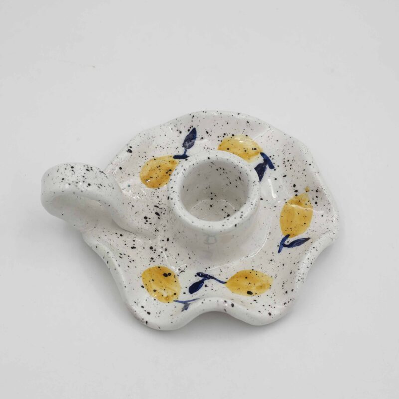 "Handmade ceramic candle holder featuring a vibrant lemon design, perfect for adding a touch of Mediterranean charm to your home decor. This artisanal candle holder showcases intricate details and bright colors, making it an ideal centerpiece for any room. Perfect for creating a warm and inviting ambiance, this lemon-themed candle holder combines functionality with artistic elegance." Greek: "Χειροποίητη κεραμική βάση για κεριά με σχέδιο λεμονιών, ιδανική για να προσθέσετε μια πινελιά μεσογειακής γοητείας στη διακόσμηση του σπιτιού σας. Αυτή η καλλιτεχνική βάση για κεριά διαθέτει περίτεχνες λεπτομέρειες και φωτεινά χρώματα, καθιστώντας την ιδανικό κεντρικό διακοσμητικό στοιχείο για κάθε δωμάτιο. Ιδανική για να δημιουργήσετε μια ζεστή και φιλόξενη ατμόσφαιρα, αυτή η βάση για κεριά με θέμα τα λεμόνια συνδυάζει λειτουργικότητα με καλλιτεχνική κομψότητα.