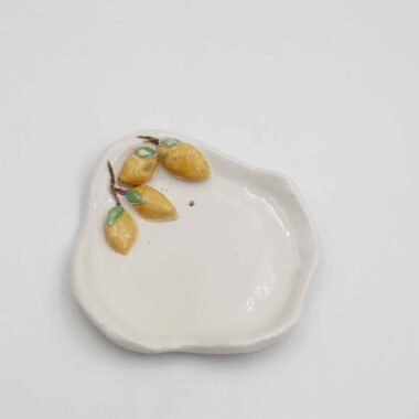 Handmade ceramic lemon plate for jewelry, perfect for adding a touch of Mediterranean charm to your dressing table. This artisanal plate features a vibrant lemon design with intricate details, ideal for organizing and displaying your favorite jewelry pieces. Stylish and functional, this lemon-themed jewelry plate makes a delightful addition to any home decor.
