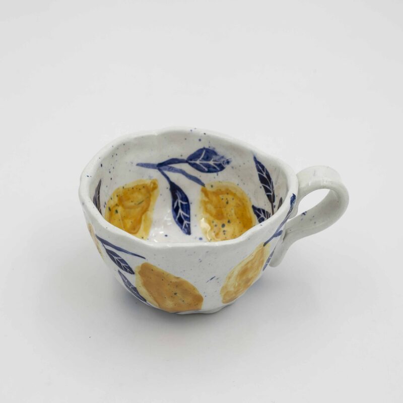 Handmade ceramic mug with lemons, perfect for adding a refreshing touch to your drinkware collection. This artisanal mug is ideal for enjoying your favorite beverages. Unique and colorful, this lemon mug is a delightful addition to any kitchen or dining space. Χειροποίητη κεραμική κούπα με λεμόνια, ιδανική για να προσθέσετε μια δροσερή πινελιά στη συλλογή σας από σκεύη. Αυτή η καλλιτεχνική κούπα διαθέτει λεμόνια με περίτεχνες λεπτομέρειες, ιδανική για να απολαμβάνετε τα αγαπημένα σας ροφήματα. Μοναδική και πολύχρωμη είναι μια υπέροχη προσθήκη σε κάθε κουζίνα ή τραπεζαρία.