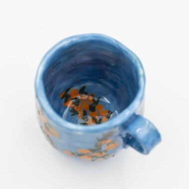 Bright and cheerful mug featuring a striking contrast of juicy oranges against a vibrant blue background. A refreshing addition to your kitchenware collection. (keywords: mug, blue background, oranges, orange mug, kitchenware) Λαμπερό και χαρούμενο φλιτζάνι με έντονη αντίθεση από ζουμερά πορτοκάλια σε φόντο ζωηρού μπλε χρώματος. Μια αναζωογονητική προσθήκη στη συλλογή σας από είδη κουζίνας. (keywords: φλιτζάνι, μπλε φόντο, πορτοκάλια, πορτοκαλί φλιτζάνι, είδη κουζίνας)