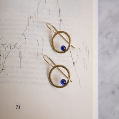 Handmade brass Phaidra circle earrings featuring beautiful blue cat eye stones, crafted by Sunny Designs. These elegant and stylish earrings are perfect for adding a touch of sophistication to any outfit and make a wonderful gift for women. Phaidra earrings, circle earrings, blue cat eye earrings, handmade brass jewelry, Sunny Designs earrings, unique gift, stylish earrings, women’s jewelry, artisan earrings, elegant earrings Χειροποίητα σκουλαρίκια Phaidra σε σχήμα κύκλου από μπρούντζο με όμορφες μπλε πέτρες ματιού της γάτας, φτιαγμένα από τη Sunny Designs. Αυτά τα κομψά και στιλάτα σκουλαρίκια είναι ιδανικά για να προσθέσουν μια αίσθηση κομψότητας σε κάθε ντύσιμο και αποτελούν μια υπέροχη επιλογή δώρου για γυναίκες. σκουλαρίκια Phaidra, κυκλικά σκουλαρίκια, σκουλαρίκια με μπλε μάτι γάτας, χειροποίητο κόσμημα από μπρούντζο, σκουλαρίκια Sunny Designs, μοναδικό δώρο, κομψά σκουλαρίκια, γυναικείο κόσμημα, κοσμήματα τέχνης, κομψά σκουλαρίκια