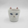 Handmade ceramic mug with a cat face design, available in calico, tuxedo, white, and orange cat variations. Perfect for cat lovers looking to add a cute, personalized touch to their drinkware collection." Greek: "Χειροποίητη κεραμική κούπα με σχέδιο προσώπου γάτας, διαθέσιμη σε εκδόσεις τρίχρωμης, δίχρωμης, λευκής και πορτοκαλί γάτας. Ιδανική για φιλόζωους που θέλουν να προσθέσουν μια χαριτωμένη, προσωπική πινελιά στη συλλογή τους από κούπες.