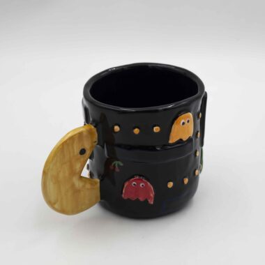 Nostalgic handmade ceramic mug featuring a classic Pac-Man design. Perfect for retro gamers and coffee lovers. Νοσταλγικό χειροποίητο κεραμικό φλιτζάνι με κλασικό σχέδιο Pac-Man. Ιδανικό για λάτρεις των retro παιχνιδιών και του καφέ.