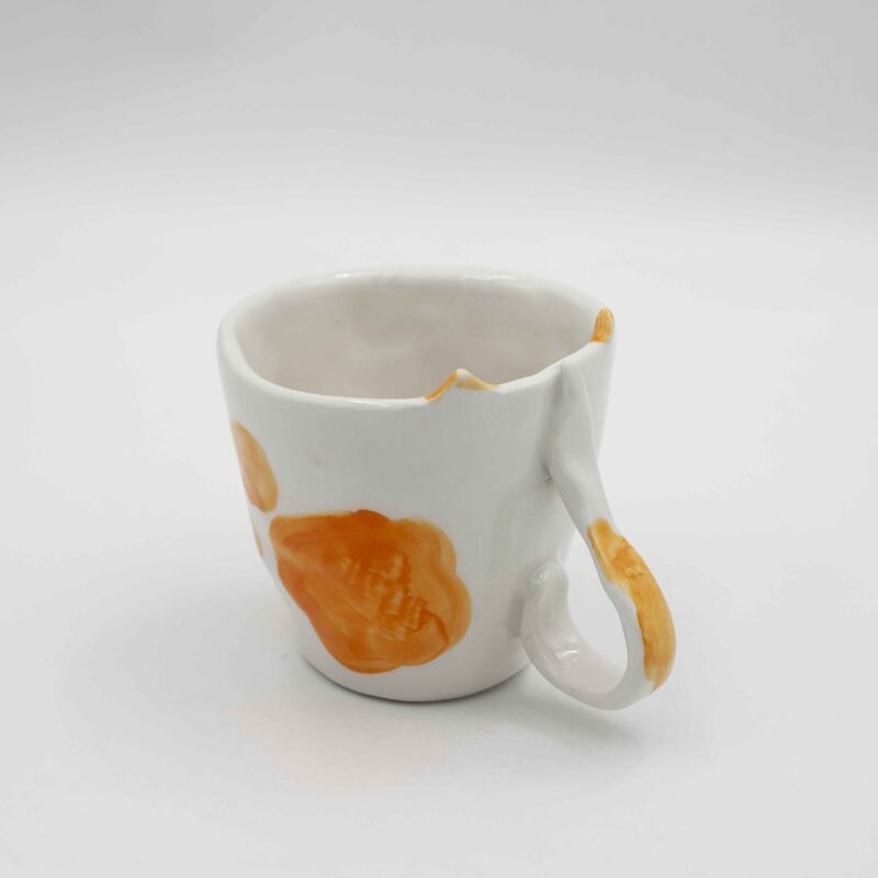 Handmade ceramic mug with a cat face design, available in calico, tuxedo, white, and orange cat variations. Perfect for cat lovers looking to add a cute, personalized touch to their drinkware collection." Greek: "Χειροποίητη κεραμική κούπα με σχέδιο προσώπου γάτας, διαθέσιμη σε εκδόσεις τρίχρωμης, δίχρωμης, λευκής και πορτοκαλί γάτας. Ιδανική για φιλόζωους που θέλουν να προσθέσουν μια χαριτωμένη, προσωπική πινελιά στη συλλογή τους από κούπες.