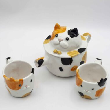 Adorable ceramic tea set featuring two cups calico cats, perfect for tea lovers and cat enthusiasts. A unique and heartwarming addition to any kitchen. Αγαπημένο σετ τσαγιού από κεραμικό με δύο φλιτζάνια γατάκια καλικό, ιδανικό για λάτρεις του τσαγιού και των γατών. Μια μοναδική και ζεστή προσθήκη σε κάθε κουζίνα.