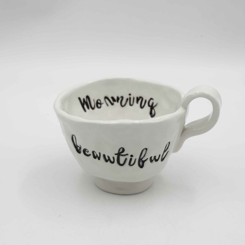 Elegant white ceramic mug with a handwritten inspirational message, perfect for daily motivation and mindfulness. Κομψό λευκό κεραμικό φλιτζάνι με χειρόγραφο εμπνευστικό μήνυμα, ιδανικό για καθημερινή κινητοποίηση και ενσυνειδητότητα.