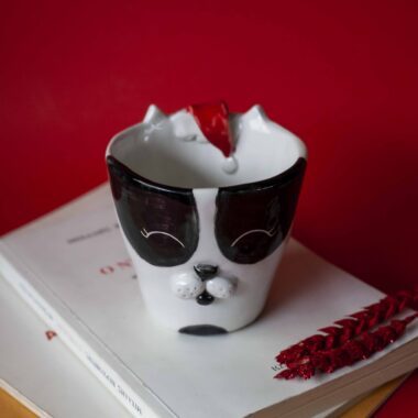 Handmade ceramic mug with a cat face design, available in calico, tuxedo, white, and orange cat variations. Perfect for cat lovers looking to add a cute, personalized touch to their drinkware collection.