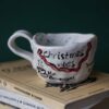 Beautiful handmade ceramic Christmas mugs featuring festive designs like gingerbread cookies and Christmas trees, perfect for cozy winter mornings. Artisan-crafted with care, ideal for gifting or enjoying hot cocoa. Unique holiday mugs made with love. "Όμορφες χειροποίητες κεραμικές κούπες για τα Χριστούγεννα, με γιορτινά σχέδια όπως μπισκότα τζίντζερμαν και χριστουγεννιάτικα δέντρα. Ιδανικές για ζεστά πρωινά του χειμώνα. Δημιουργημένες με μεράκι, τέλειες για δώρα ή για απολαυστική ζεστή σοκολάτα. Μοναδικές εορταστικές κούπες φτιαγμένες με αγάπη