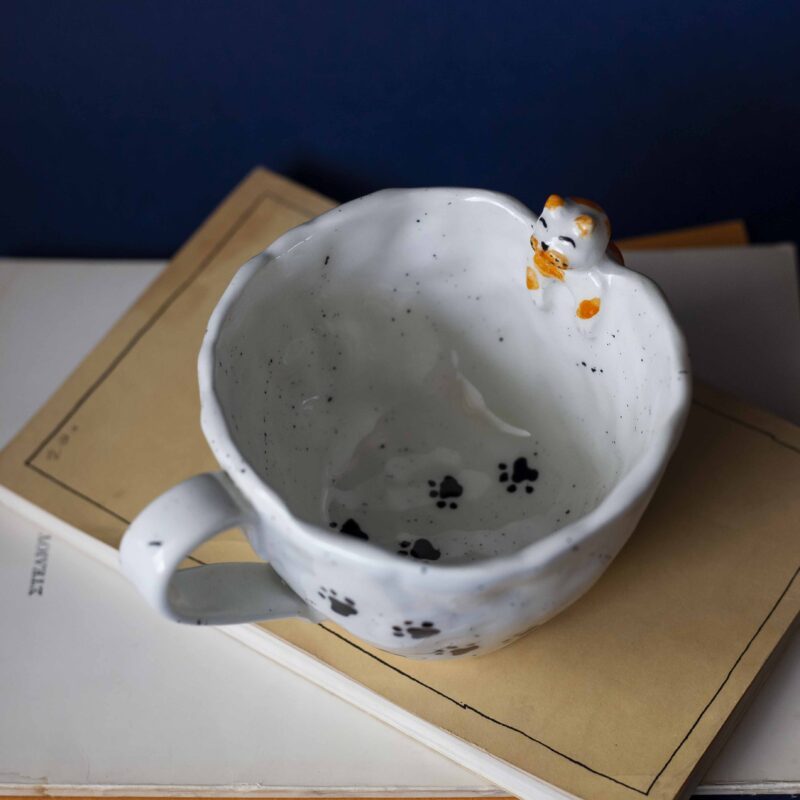 Large handmade ceramic mugs featuring adorable 3D cats climbing on the sides, perfect for cat lovers and tea or coffee enthusiasts. Unique artisan-crafted design combining functionality with playful charm. Ideal as a gift or for adding a whimsical touch to your daily routine. Μεγάλες χειροποίητες κεραμικές κούπες με χαριτωμένες τρισδιάστατες γάτες που σκαρφαλώνουν στις πλευρές τους. Ιδανικές για λάτρεις των γατών και του καφέ ή του τσαγιού. Μοναδικός καλλιτεχνικός σχεδιασμός που συνδυάζει λειτουργικότητα με παιχνιδιάρικη γοητεία. Τέλειες για δώρα ή για να προσθέσετε μια χαρούμενη πινελιά στην καθημερινότητά σας.