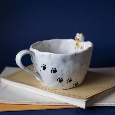 Large handmade ceramic mugs featuring adorable 3D cats climbing on the sides, perfect for cat lovers and tea or coffee enthusiasts. Unique artisan-crafted design combining functionality with playful charm. Ideal as a gift or for adding a whimsical touch to your daily routine. Μεγάλες χειροποίητες κεραμικές κούπες με χαριτωμένες τρισδιάστατες γάτες που σκαρφαλώνουν στις πλευρές τους. Ιδανικές για λάτρεις των γατών και του καφέ ή του τσαγιού. Μοναδικός καλλιτεχνικός σχεδιασμός που συνδυάζει λειτουργικότητα με παιχνιδιάρικη γοητεία. Τέλειες για δώρα ή για να προσθέσετε μια χαρούμενη πινελιά στην καθημερινότητά σας.