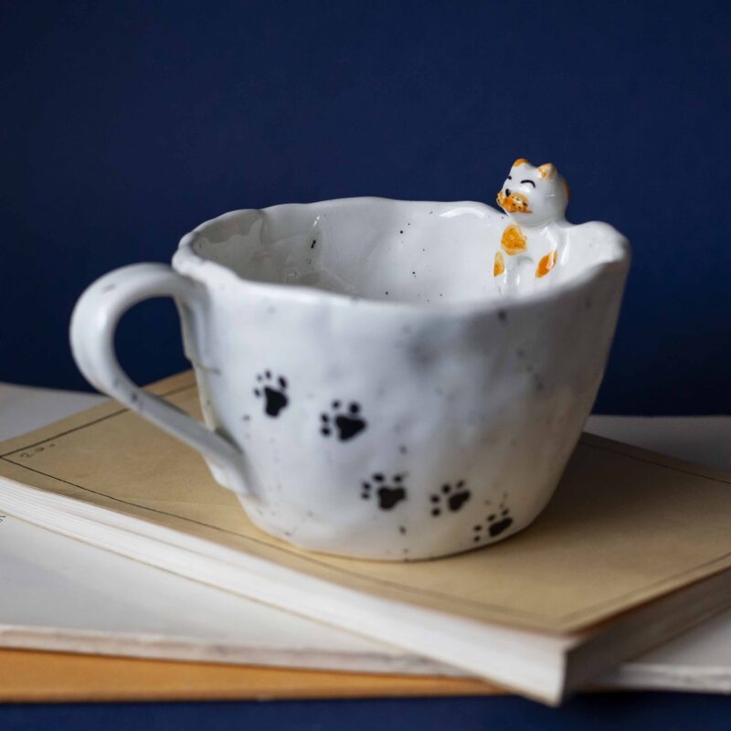 Large handmade ceramic mugs featuring adorable 3D cats climbing on the sides, perfect for cat lovers and tea or coffee enthusiasts. Unique artisan-crafted design combining functionality with playful charm. Ideal as a gift or for adding a whimsical touch to your daily routine. Μεγάλες χειροποίητες κεραμικές κούπες με χαριτωμένες τρισδιάστατες γάτες που σκαρφαλώνουν στις πλευρές τους. Ιδανικές για λάτρεις των γατών και του καφέ ή του τσαγιού. Μοναδικός καλλιτεχνικός σχεδιασμός που συνδυάζει λειτουργικότητα με παιχνιδιάρικη γοητεία. Τέλειες για δώρα ή για να προσθέσετε μια χαρούμενη πινελιά στην καθημερινότητά σας.