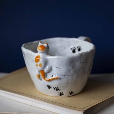 Large handmade ceramic mugs featuring adorable 3D cats climbing on the sides, perfect for cat lovers and tea or coffee enthusiasts. Unique artisan-crafted design combining functionality with playful charm. Ideal as a gift or for adding a whimsical touch to your daily routine. Μεγάλες χειροποίητες κεραμικές κούπες με χαριτωμένες τρισδιάστατες γάτες που σκαρφαλώνουν στις πλευρές τους. Ιδανικές για λάτρεις των γατών και του καφέ ή του τσαγιού. Μοναδικός καλλιτεχνικός σχεδιασμός που συνδυάζει λειτουργικότητα με παιχνιδιάρικη γοητεία. Τέλειες για δώρα ή για να προσθέσετε μια χαρούμενη πινελιά στην καθημερινότητά σας.