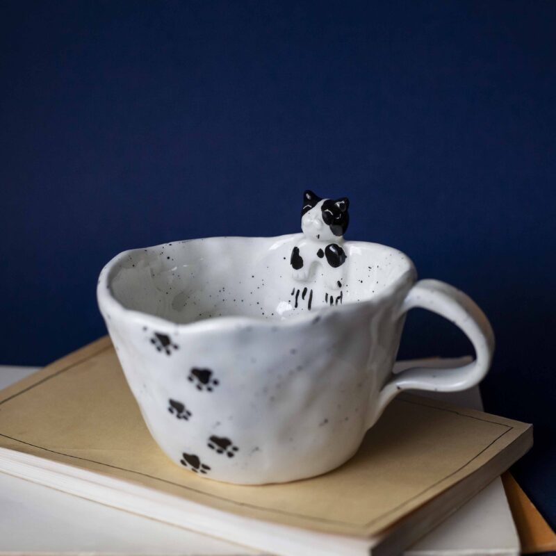 Large handmade ceramic mugs featuring adorable 3D cats climbing on the sides, perfect for cat lovers and tea or coffee enthusiasts. Unique artisan-crafted design combining functionality with playful charm. Ideal as a gift or for adding a whimsical touch to your daily routine. Μεγάλες χειροποίητες κεραμικές κούπες με χαριτωμένες τρισδιάστατες γάτες που σκαρφαλώνουν στις πλευρές τους. Ιδανικές για λάτρεις των γατών και του καφέ ή του τσαγιού. Μοναδικός καλλιτεχνικός σχεδιασμός που συνδυάζει λειτουργικότητα με παιχνιδιάρικη γοητεία. Τέλειες για δώρα ή για να προσθέσετε μια χαρούμενη πινελιά στην καθημερινότητά σας.