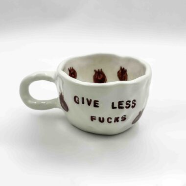 Handmade ceramic mugs adorned with playful fruit designs and the bold message 'Give Less Fucks' on the front. Perfect for adding a touch of humor and personality to your daily coffee or tea!