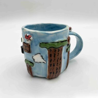 Handcrafted Super Mario-themed pottery collection featuring a 3D mug inspired by the iconic Sky Level, colorful coasters with pixel art designs, and a charming mushroom-shaped ashtray. Perfect for gamers and pottery lovers! Χειροποίητη συλλογή κεραμικών με θέμα τον Super Mario, που περιλαμβάνει μια 3D κούπα εμπνευσμένη από το εμβληματικό Sky Level, πολύχρωμα σουβέρ με pixel art σχέδια και ένα χαριτωμένο τασάκι σε σχήμα μανιταριού. Ιδανικό για gamers και λάτρεις της κεραμικής!