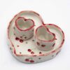 Handmade ceramic heart-shaped set, featuring a large heart plate and two matching heart cups, beautifully hand-painted with cherries. A romantic and charming design, perfect for sharing special moments over coffee or tea. Ideal for Valentine's Day, anniversaries, or as a unique gift for someone you love." Χειροποίητο κεραμικό σετ σε σχήμα καρδιάς, που περιλαμβάνει ένα μεγάλο πιάτο καρδιά και δύο ασορτί κούπες, διακοσμημένα με ζωγραφισμένα στο χέρι κεράσια. Ένα ρομαντικό και γοητευτικό σχέδιο, ιδανικό για να μοιράζεστε ξεχωριστές στιγμές με καφέ ή τσάι. Τέλειο για την Ημέρα του Αγίου Βαλεντίνου, επετείους ή ως μοναδικό δώρο για ένα αγαπημένο σας πρόσωπο.