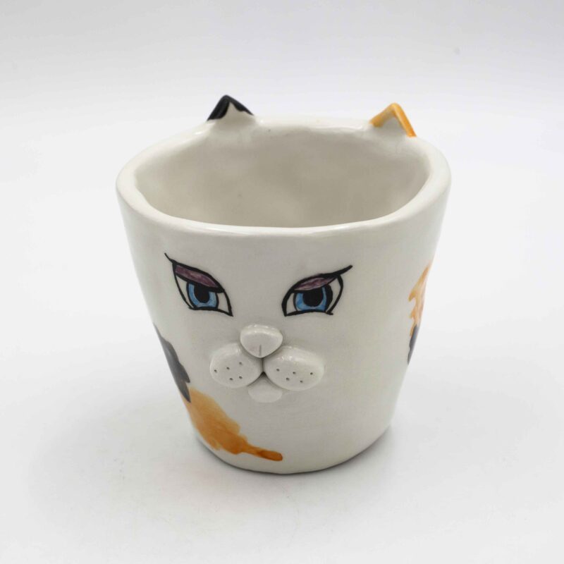 Adorable handmade ceramic cat mugs with a 3D snout and ears, bringing a playful and cozy touch to your coffee or tea time. Designed for cat lovers, these unique mugs combine artistic craftsmanship with functionality, making them the perfect gift or collectible piece. Χαριτωμένες χειροποίητες κεραμικές κούπες γάτας με τρισδιάστατη μουσούδα και αυτιά, που προσθέτουν μια παιχνιδιάρικη και ζεστή πινελιά στον καφέ ή το τσάι σας. Σχεδιασμένες για λάτρεις των γατών, αυτές οι μοναδικές κούπες συνδυάζουν την καλλιτεχνική δημιουργία με την πρακτικότητα, αποτελώντας το τέλειο δώρο ή συλλεκτικό κομμάτι.