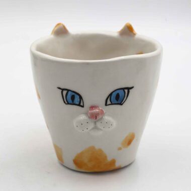 Adorable handmade ceramic cat mugs with a 3D snout and ears, bringing a playful and cozy touch to your coffee or tea time. Designed for cat lovers, these unique mugs combine artistic craftsmanship with functionality, making them the perfect gift or collectible piece. Χαριτωμένες χειροποίητες κεραμικές κούπες γάτας με τρισδιάστατη μουσούδα και αυτιά, που προσθέτουν μια παιχνιδιάρικη και ζεστή πινελιά στον καφέ ή το τσάι σας. Σχεδιασμένες για λάτρεις των γατών, αυτές οι μοναδικές κούπες συνδυάζουν την καλλιτεχνική δημιουργία με την πρακτικότητα, αποτελώντας το τέλειο δώρο ή συλλεκτικό κομμάτι.