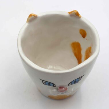 Adorable handmade ceramic cat mugs with a 3D snout and ears, bringing a playful and cozy touch to your coffee or tea time. Designed for cat lovers, these unique mugs combine artistic craftsmanship with functionality, making them the perfect gift or collectible piece. Χαριτωμένες χειροποίητες κεραμικές κούπες γάτας με τρισδιάστατη μουσούδα και αυτιά, που προσθέτουν μια παιχνιδιάρικη και ζεστή πινελιά στον καφέ ή το τσάι σας. Σχεδιασμένες για λάτρεις των γατών, αυτές οι μοναδικές κούπες συνδυάζουν την καλλιτεχνική δημιουργία με την πρακτικότητα, αποτελώντας το τέλειο δώρο ή συλλεκτικό κομμάτι.