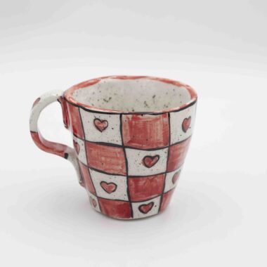 Red chessboard ceramic mug with hearts on the white squares. A unique and romantic coffee mug, perfect for tea or coffee lovers. Stylish and playful design, ideal for everyday use or as a thoughtful gift. Κεραμική κούπα με κόκκινο σκακιέρα σχέδιο και καρδιές στα λευκά τετράγωνα. Μοναδική και ρομαντική κούπα καφέ, ιδανική για λάτρεις του τσαγιού και του καφέ. Στιλάτος και παιχνιδιάρικος σχεδιασμός, τέλειος για καθημερινή χρήση ή ως ξεχωριστό δώρο.