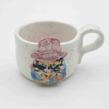 a beautiful mug with a 3d cat with a hat and flowers. a beautiful spring mug for cappuccino and tea with pink and black dots. Μία όμορφη κούπα με 3ντι γάτο με καπέλο και λουλούδια και πιτσιλιές σε ρόζ και μαύρο. Κατάλληλη για καπουτσίνο και τσάι.