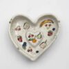 Handmade heart-shaped ceramic ashtrays, designed with love and artistic charm. Each piece features delicate hand-painted details, including cherries, colorful fruits, flowers, and tiny hearts—perfect for Valentine's Day or as a unique decorative accent. A stylish and functional ceramic creation that adds a romantic and playful touch to any space. Χειροποίητα κεραμικά τασάκια σε σχήμα καρδιάς, σχεδιασμένα με αγάπη και καλλιτεχνική φινέτσα. Κάθε κομμάτι διακοσμείται με λεπτεπίλεπτες, ζωγραφισμένες στο χέρι λεπτομέρειες, όπως κεράσια, πολύχρωμα φρούτα, λουλούδια και μικρές καρδιές—ιδανικό για την Ημέρα του Αγίου Βαλεντίνου ή ως μοναδικό διακοσμητικό στοιχείο. Ένα στυλάτο και λειτουργικό κεραμικό δημιούργημα που προσθέτει ρομαντική και παιχνιδιάρικη πινελιά σε κάθε χώρο.