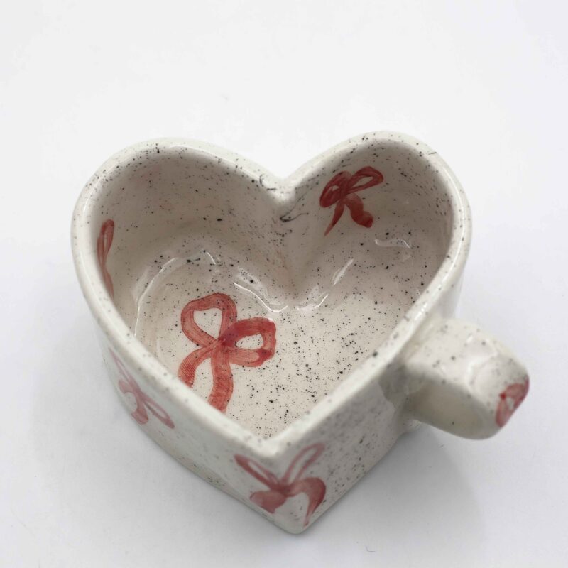 Handmade heart-shaped ceramic mugs, perfect for Valentine's Day and romantic moments. Each mug is decorated with charming hand-painted details, featuring cherries, an array of fruits, delicate flowers, and tiny hearts. A unique and thoughtful gift for loved ones, blending artistic beauty with everyday warmth and love. Χειροποίητες κεραμικές κούπες σε σχήμα καρδιάς, ιδανικές για την Ημέρα του Αγίου Βαλεντίνου και ρομαντικές στιγμές. Κάθε κούπα είναι διακοσμημένη με χαριτωμένες, ζωγραφισμένες στο χέρι λεπτομέρειες, όπως κεράσια, διάφορα φρούτα, λεπτεπίλεπτα λουλούδια και μικρές καρδιές. Ένα μοναδικό και τρυφερό δώρο για τα αγαπημένα σας πρόσωπα, που συνδυάζει την τέχνη με τη ζεστασιά της καθημερινότητας.