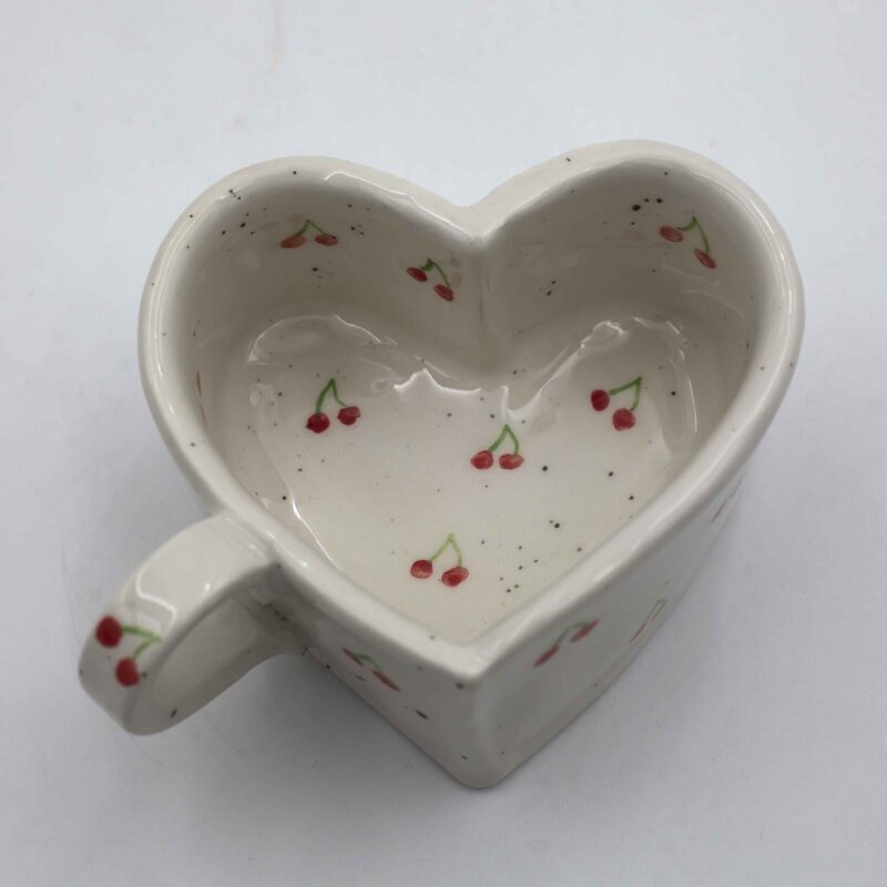 Handmade heart-shaped ceramic mugs, perfect for Valentine's Day and romantic moments. Each mug is decorated with charming hand-painted details, featuring cherries, an array of fruits, delicate flowers, and tiny hearts. A unique and thoughtful gift for loved ones, blending artistic beauty with everyday warmth and love. Χειροποίητες κεραμικές κούπες σε σχήμα καρδιάς, ιδανικές για την Ημέρα του Αγίου Βαλεντίνου και ρομαντικές στιγμές. Κάθε κούπα είναι διακοσμημένη με χαριτωμένες, ζωγραφισμένες στο χέρι λεπτομέρειες, όπως κεράσια, διάφορα φρούτα, λεπτεπίλεπτα λουλούδια και μικρές καρδιές. Ένα μοναδικό και τρυφερό δώρο για τα αγαπημένα σας πρόσωπα, που συνδυάζει την τέχνη με τη ζεστασιά της καθημερινότητας.