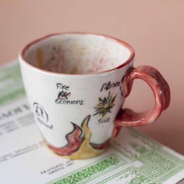 handmade ceramic mug about leo. with leo vibes, symbols and planets. Χειροποίητη κεραμική κούπα του λέοντα με φωτιές και σύμβολα και πλανήτες.