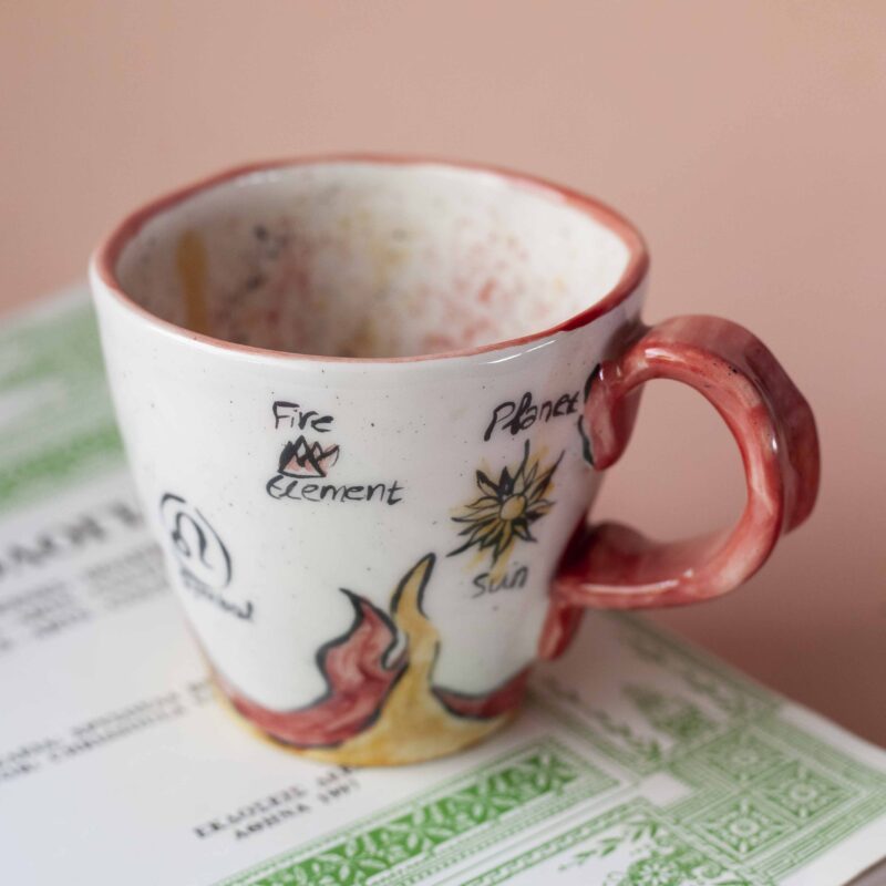 handmade ceramic mug about leo. with leo vibes, symbols and planets. Χειροποίητη κεραμική κούπα του λέοντα με φωτιές και σύμβολα και πλανήτες.