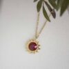 Sun necklace with red stone, handmade brass pendant plated in 24k gold on a stainless steel chain. Bold celestial-inspired artisan jewelry with vibrant red gemstone detail, affordable handmade accessory by Sunny Designs small business.Κολιέ Sun με κόκκινη πέτρα, χειροποίητο μενταγιόν από ορείχαλκο επιχρυσωμένο 24 καράτια σε ατσάλινη αλυσίδα. Εντυπωσιακό κόσμημα εμπνευσμένο από τα ουράνια σύμβολα με ζωντανή κόκκινη πέτρα, προσιτό χειροποίητο αξεσουάρ από τη μικρή επιχείρηση Sunny Designs.
